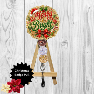 A Christmas-themed metal badge pull featuring a round gold glitter sign that reads 'Merry Bright' with red lettering, green holly, candy canes, and a red bow. The sign is mounted on a small wooden A-frame stand with three decorative round badge holders and a black metal hook at the bottom.