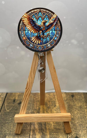Eagle House badge pull with shimmer glitter displayed on a wooden easel showcasing vibrant eagle design.