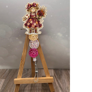 Girl scarecrow retractable badge reel with glittery champagne background and colorful sparkling beads.