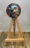 Colorful hummingbird badge pulls displayed on a wooden easel with floral details, perfect for brightening up uniforms.