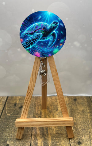Colorful sea turtle badge pull design displayed on a wooden easel, showcasing ocean vibes for ID badges.