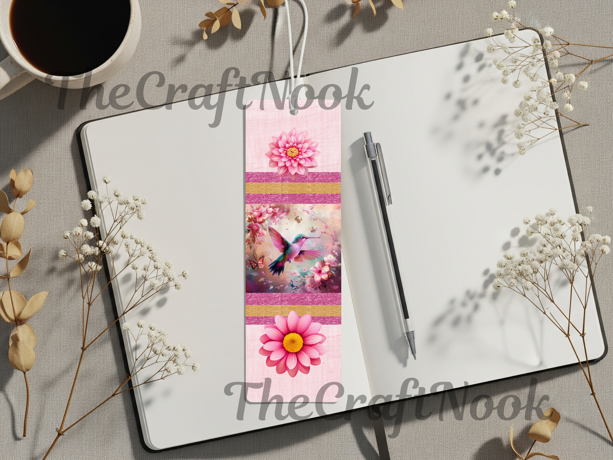 Hummingbird aluminum bookmarks displayed in a stylish notebook with floral accents and a coffee cup.