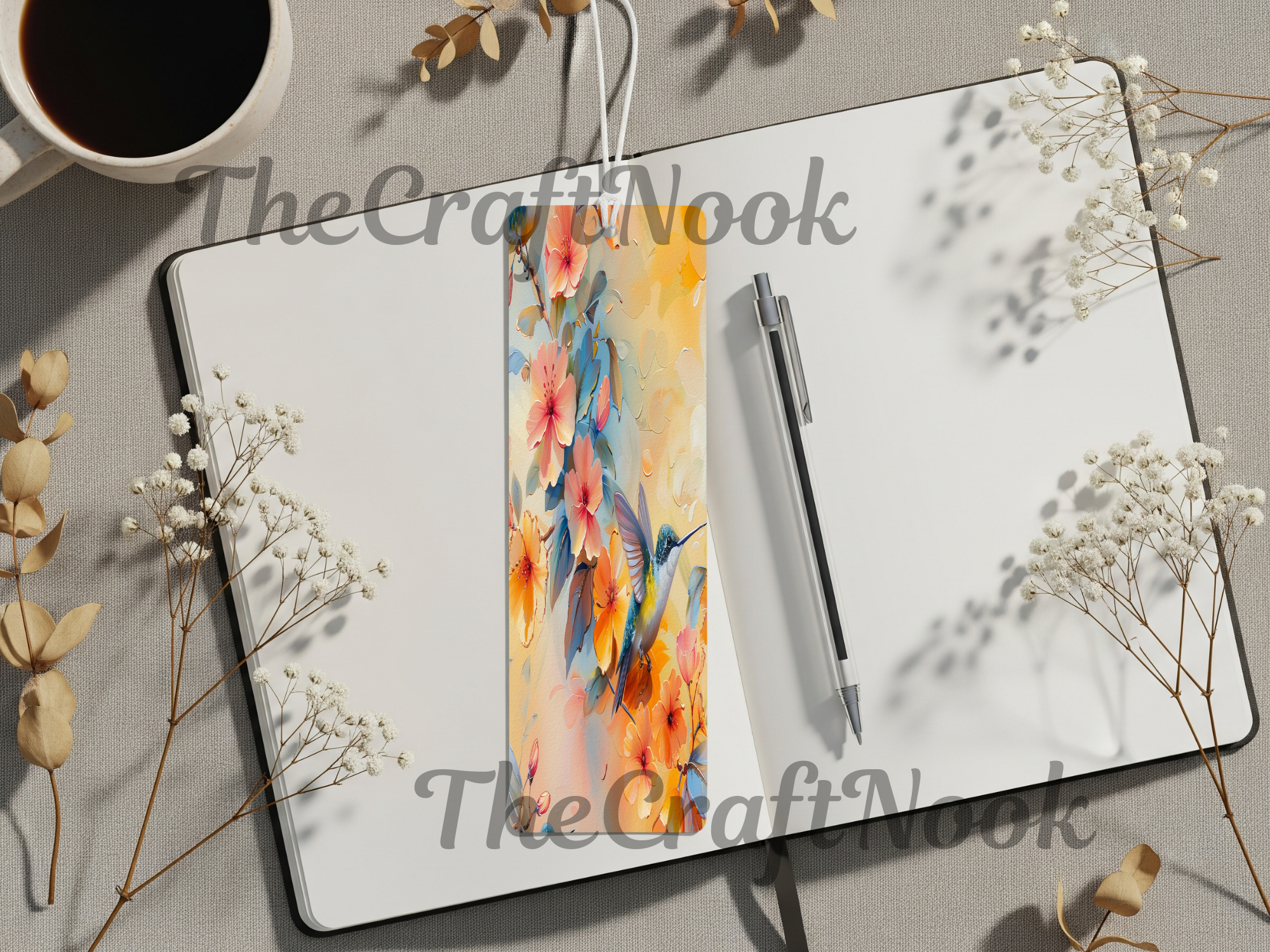 Hummingbird aluminum bookmarks placed on a notebook with flowers and a coffee cup for a vibrant reading experience.