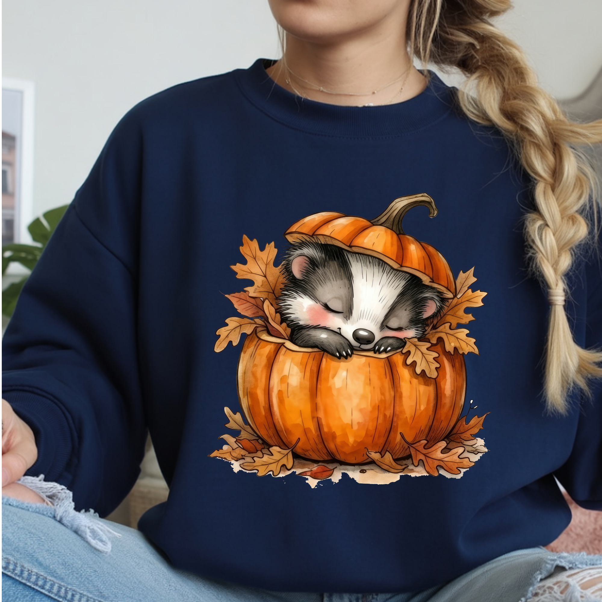 Cozy Badger Long Sleeve Tee featuring a cute badger sleeping in a pumpkin with autumn leaves.