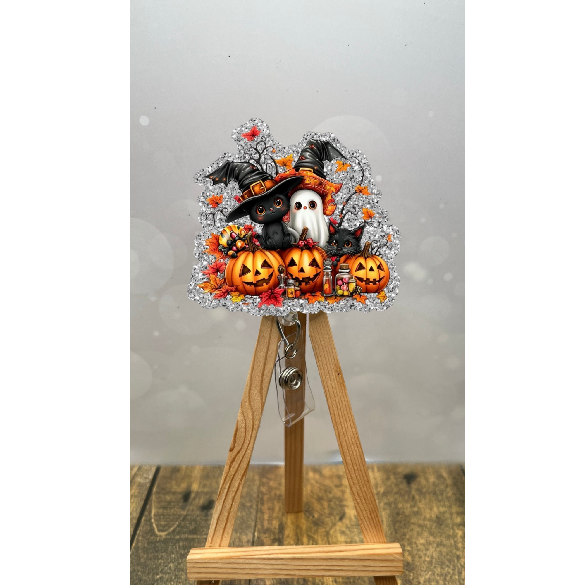 Pumpkin Patch Pals Badge Pull featuring a ghost, black cats, and pumpkins on a silver glitter background.