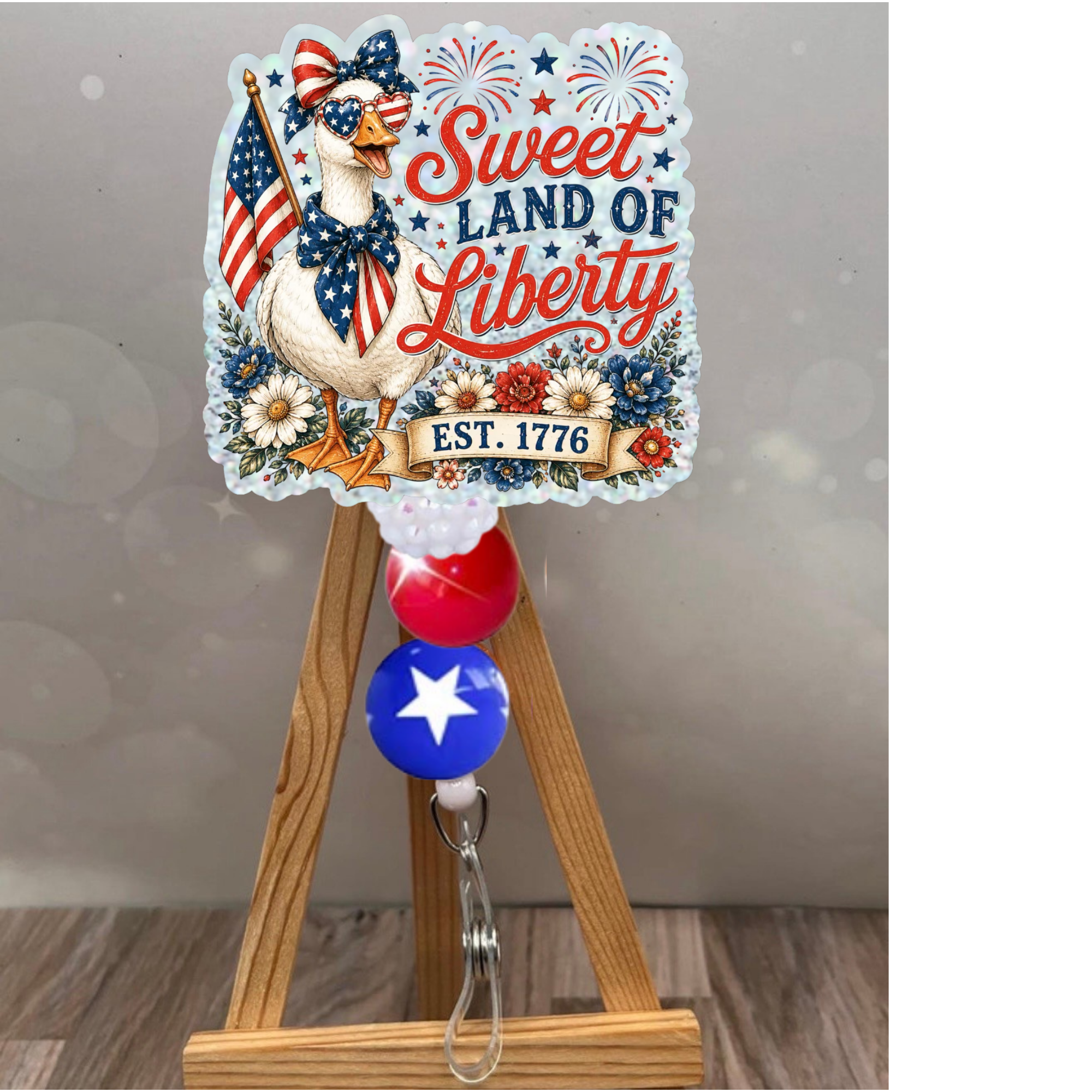 Patriotic badge reel featuring 'Sweet Land of Liberty' design with glitter background and star embellishments.