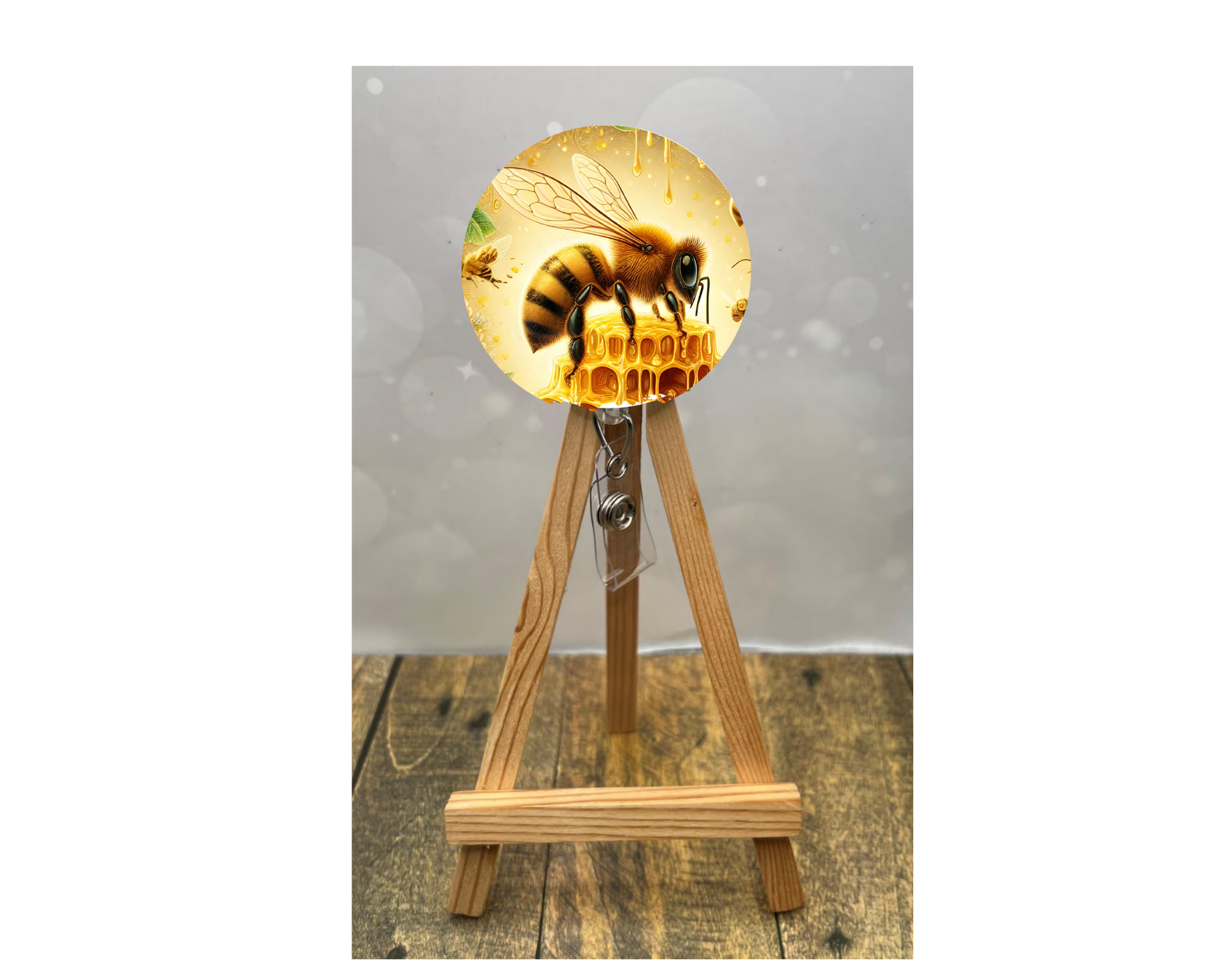 Cute honeybee badge pulls featuring a vibrant bee design on a badge reel with honeycomb and shine.