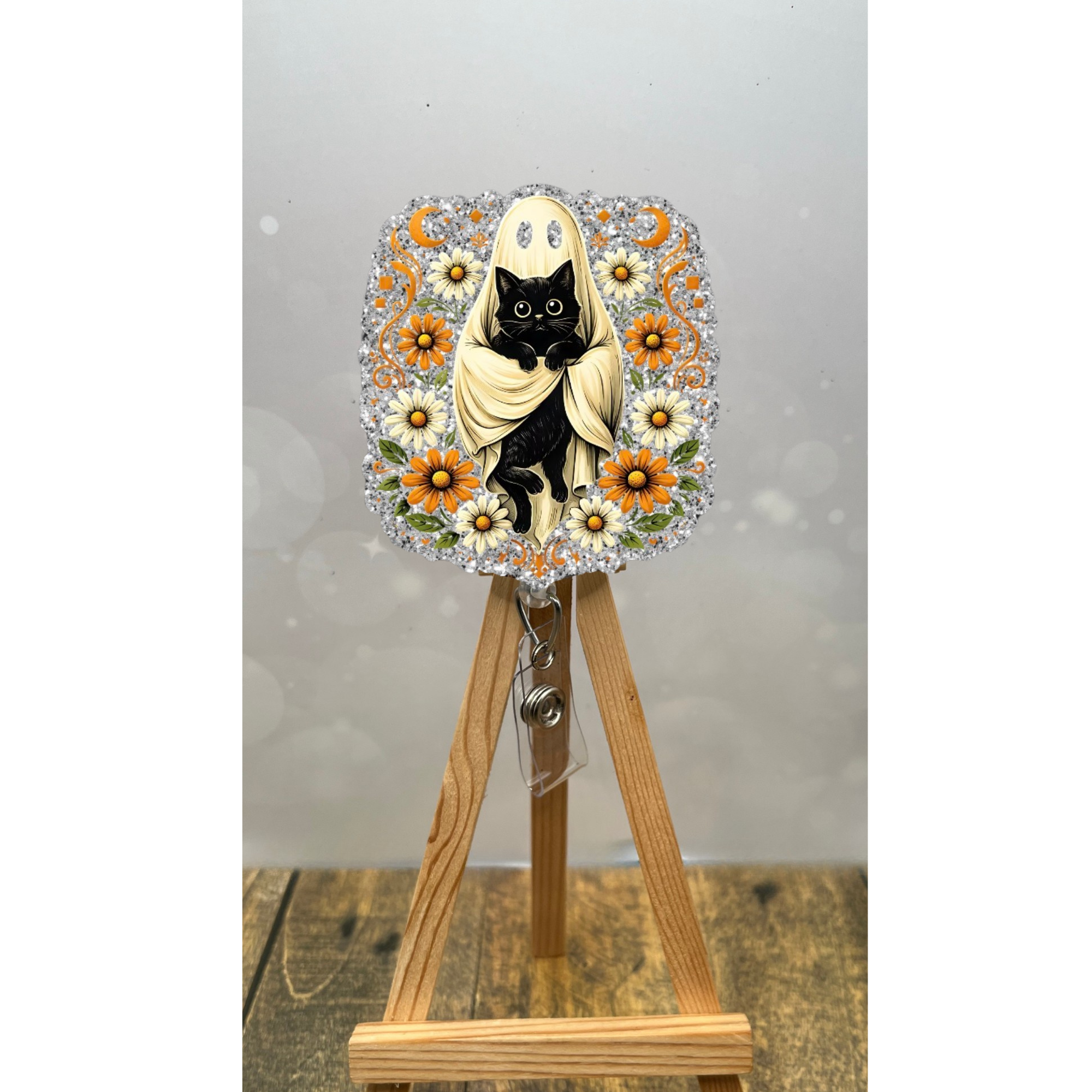 Cute Halloween badge reel featuring a ghost cat design with flowers and a glitter background.
