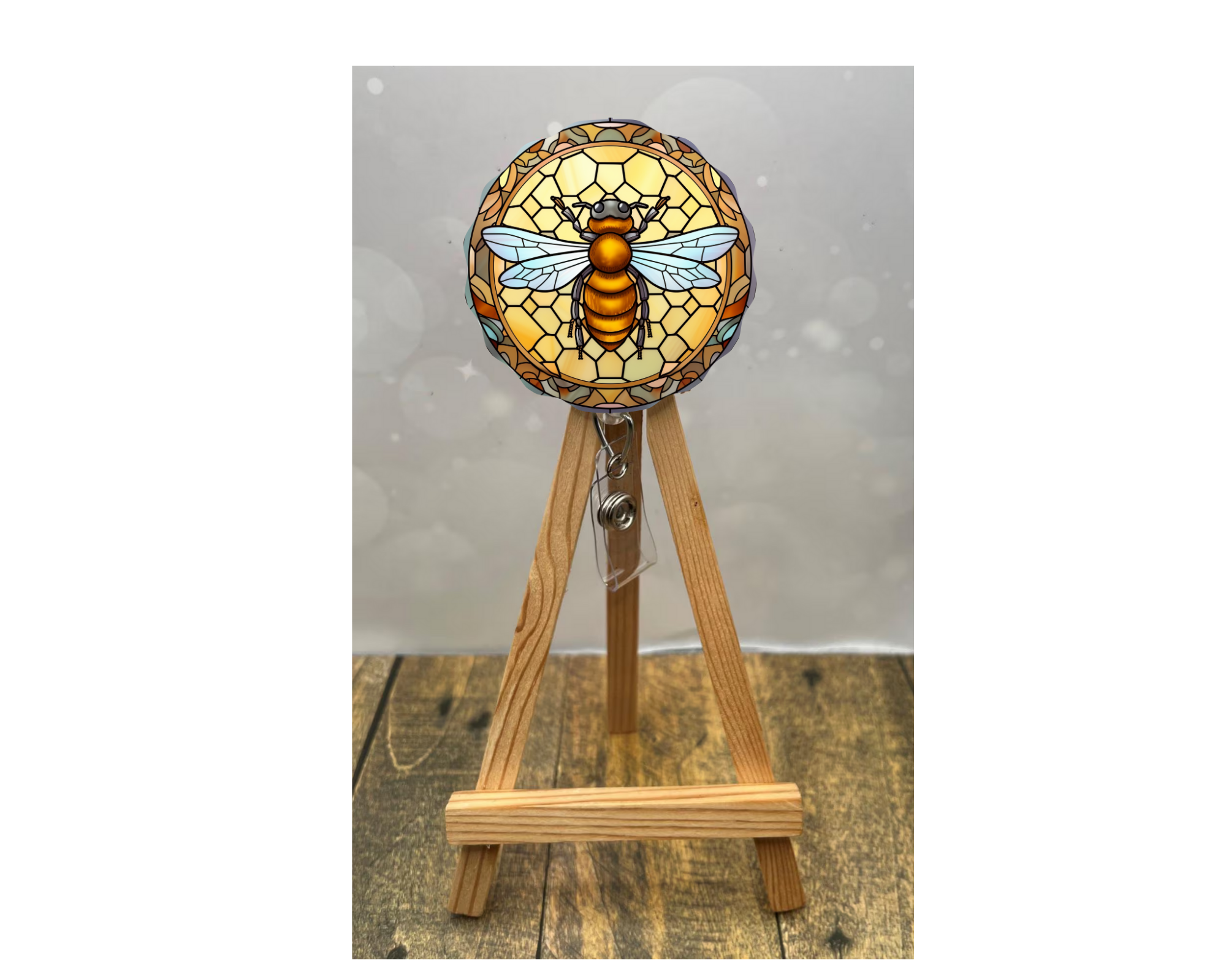 Cute honeybee badge pulls displayed on an easel with bright bee artwork and floral design.