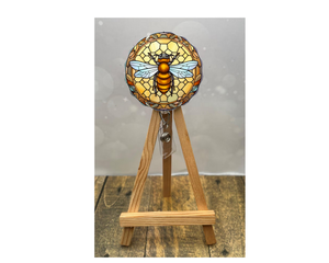 Cute honeybee badge pulls displayed on an easel with bright bee artwork and floral design.
