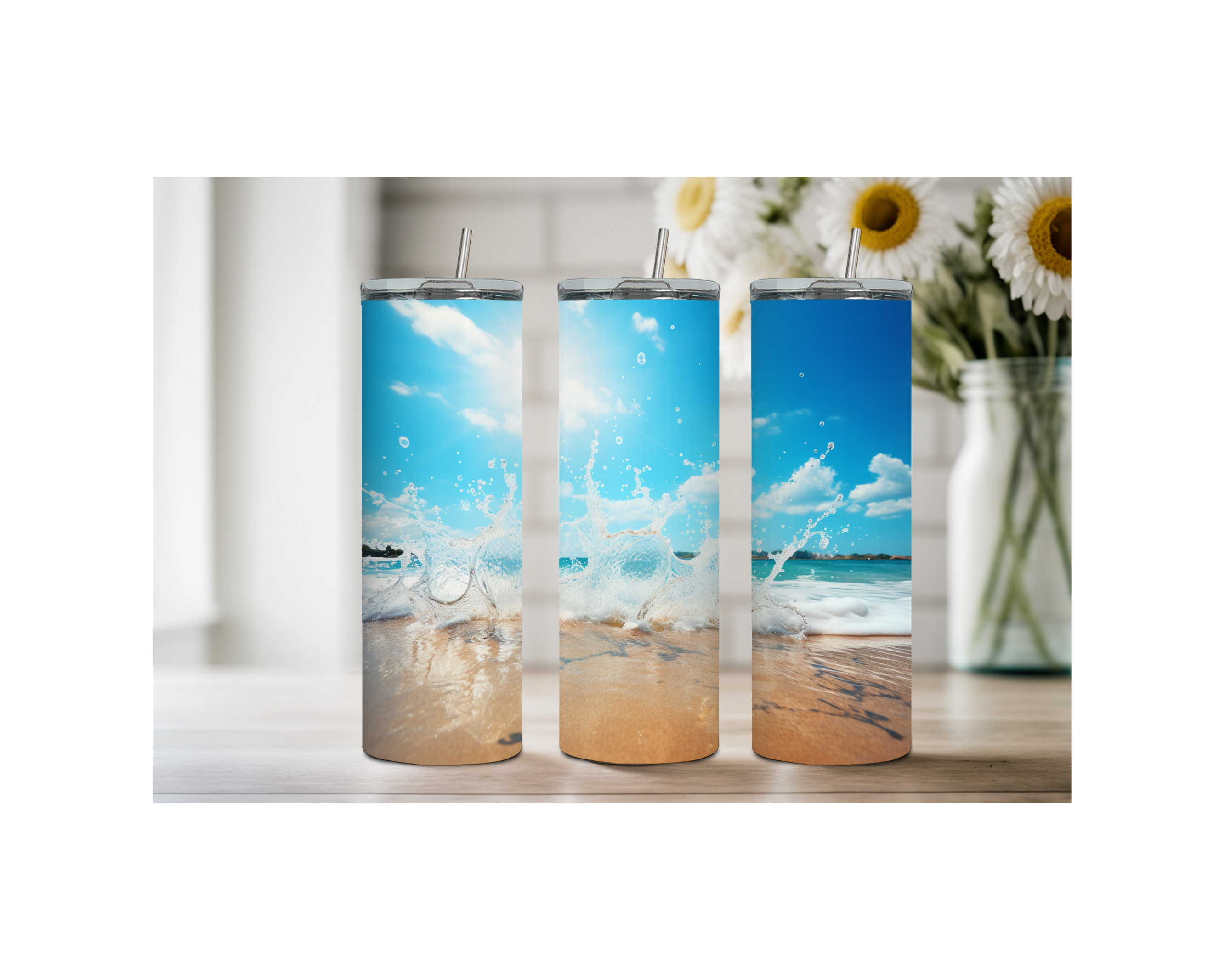 Beach stainless steel tumblers with ocean splash design on a wooden table surrounded by flowers.