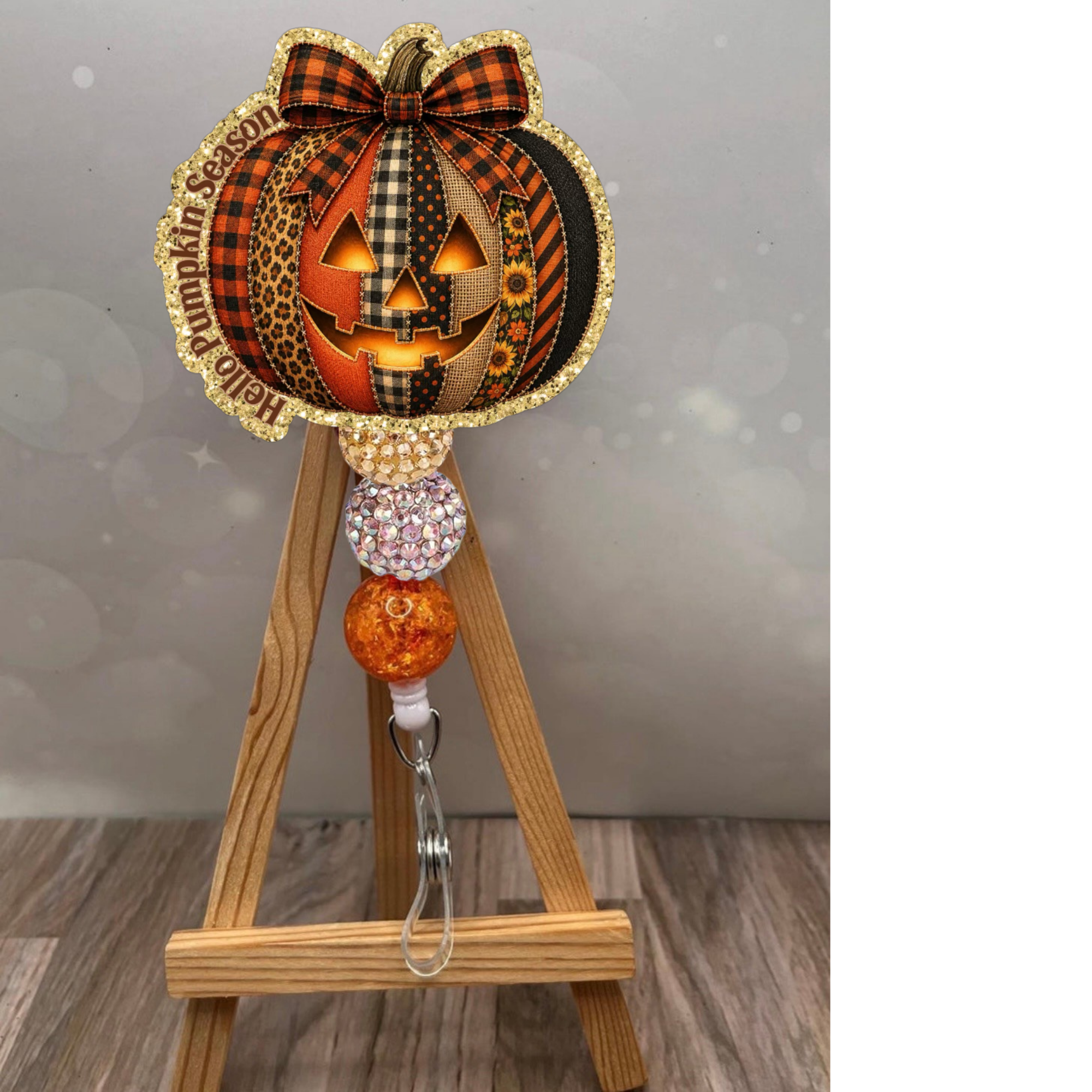 Cheerful pumpkin badge reel with glitter background, featuring Halloween design and vivid colors for festive office wear.