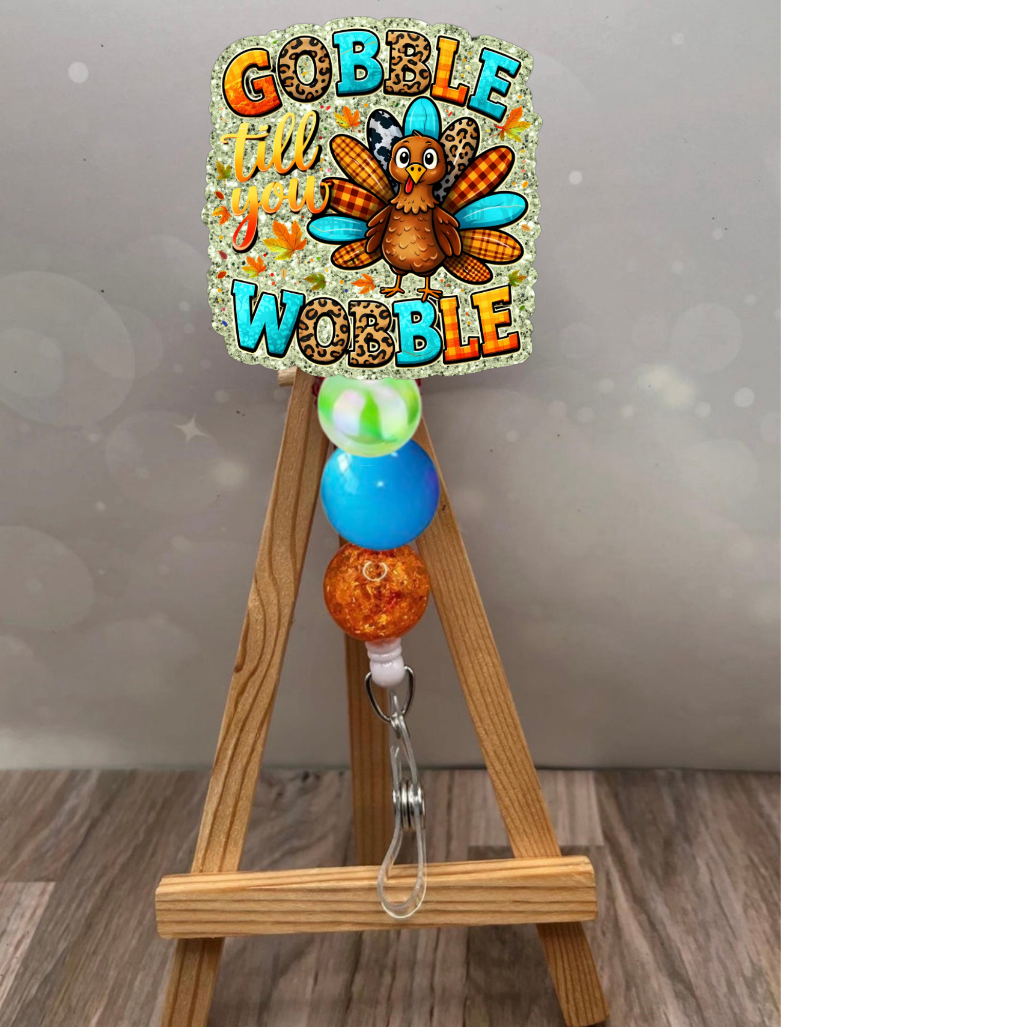 Thanksgiving retractable badge reel featuring 'Gobble Till You Wobble' design with glitter background and colorful beads.