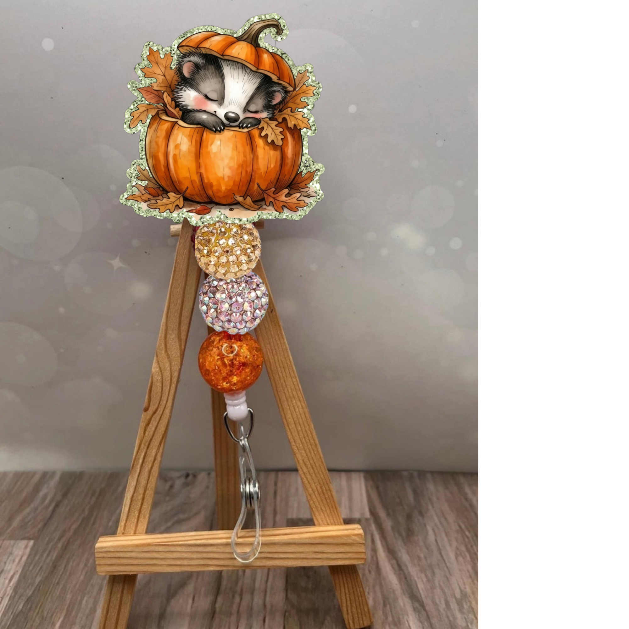 Cozy badger badge reel with an adorable badger in a pumpkin, featuring glittery beads on a retractable design.