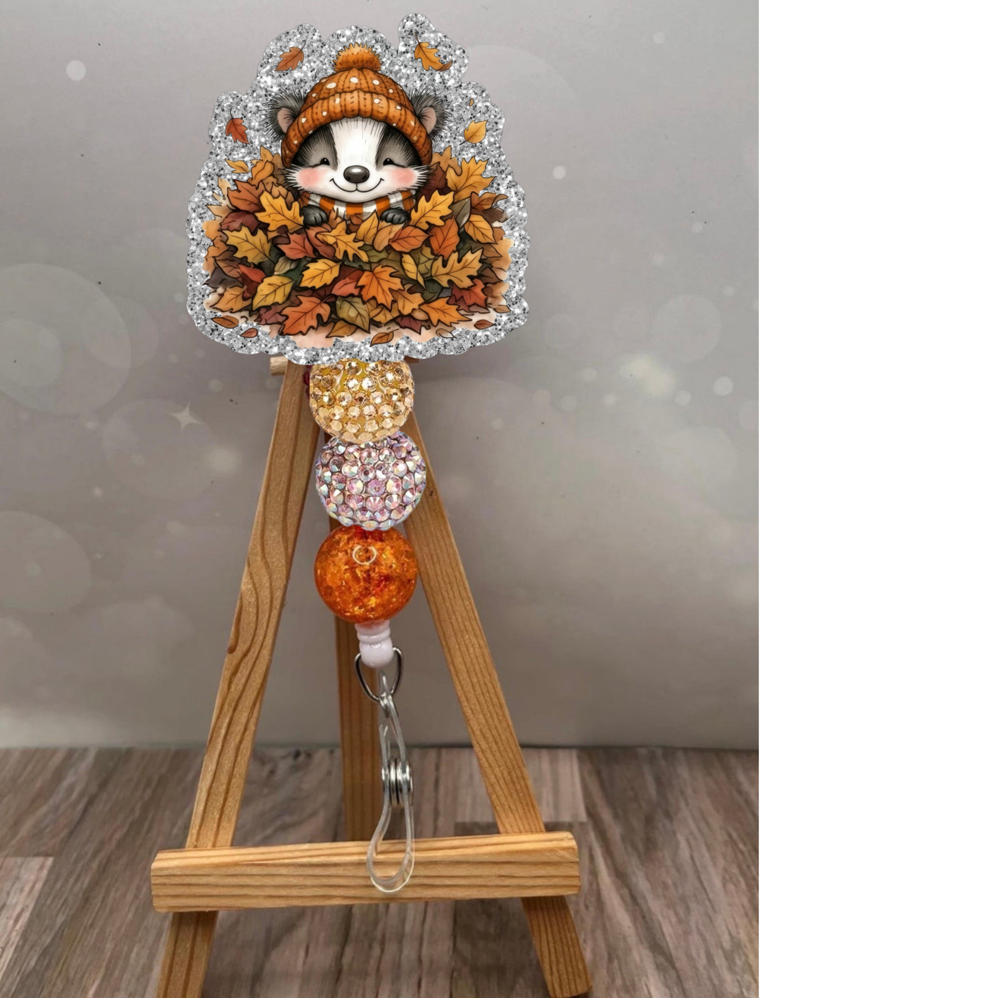 Fall themed retractable badge reel featuring a cute badger surrounded by autumn leaves and a glittery background.