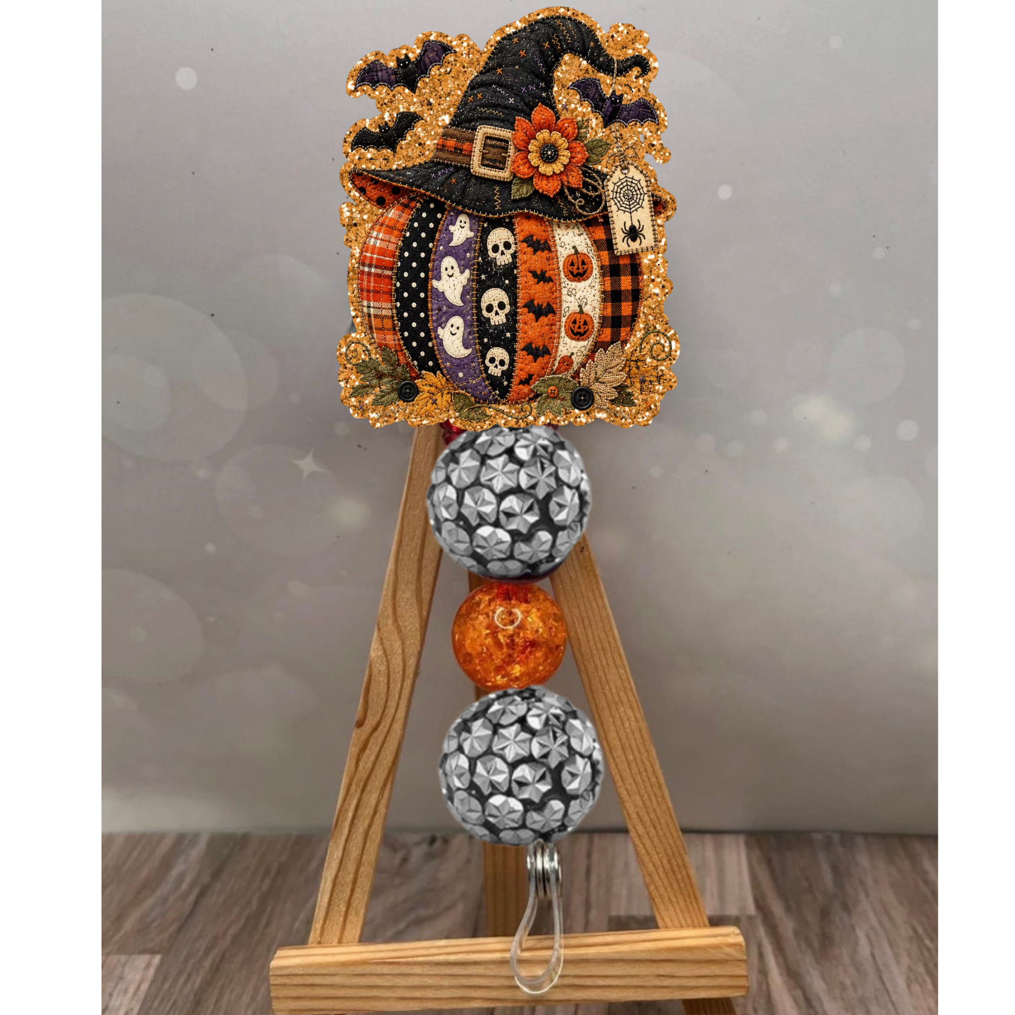 Colorful patchwork pumpkin badge reel with orange glitter background, perfect for fall enthusiasts.