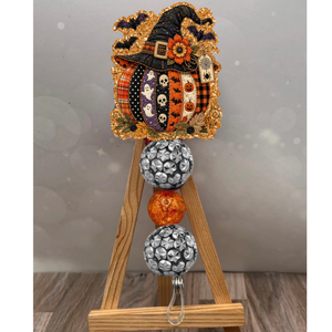 Colorful patchwork pumpkin badge reel with orange glitter background, perfect for fall enthusiasts.