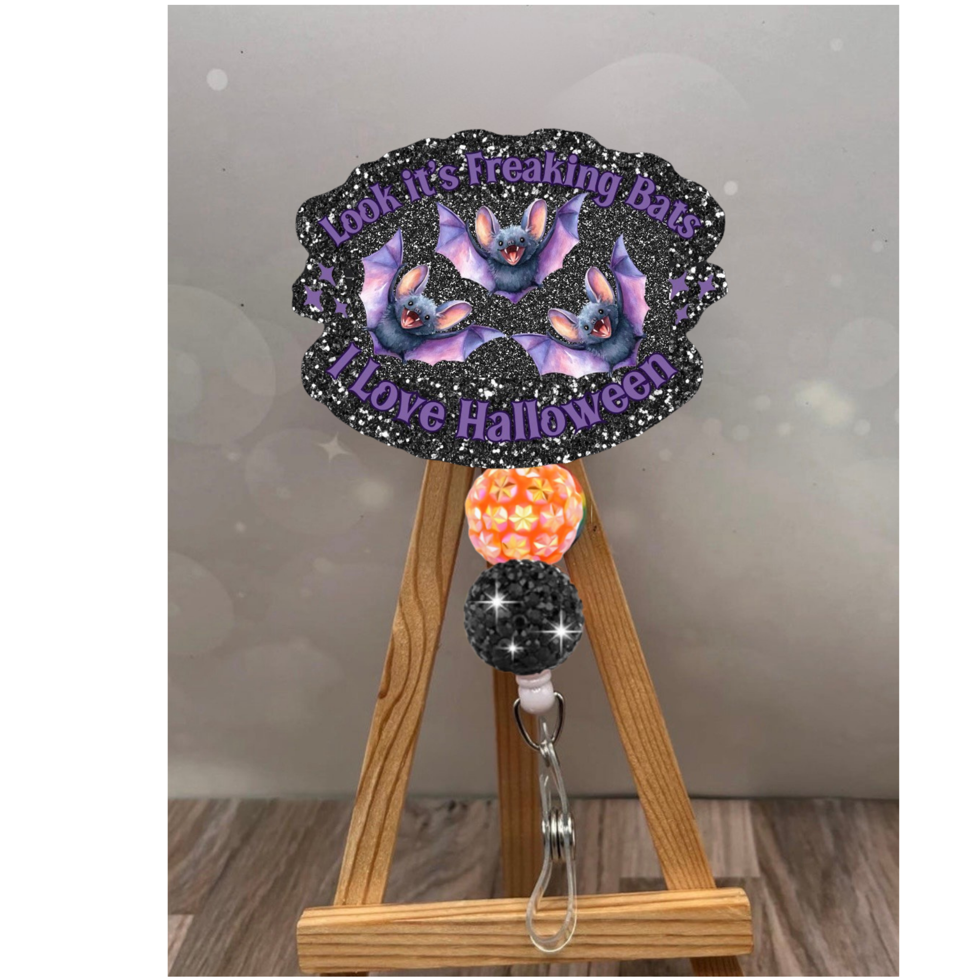 Funny Halloween badge pull featuring glittery bats design with colorful beads on retractable reel.