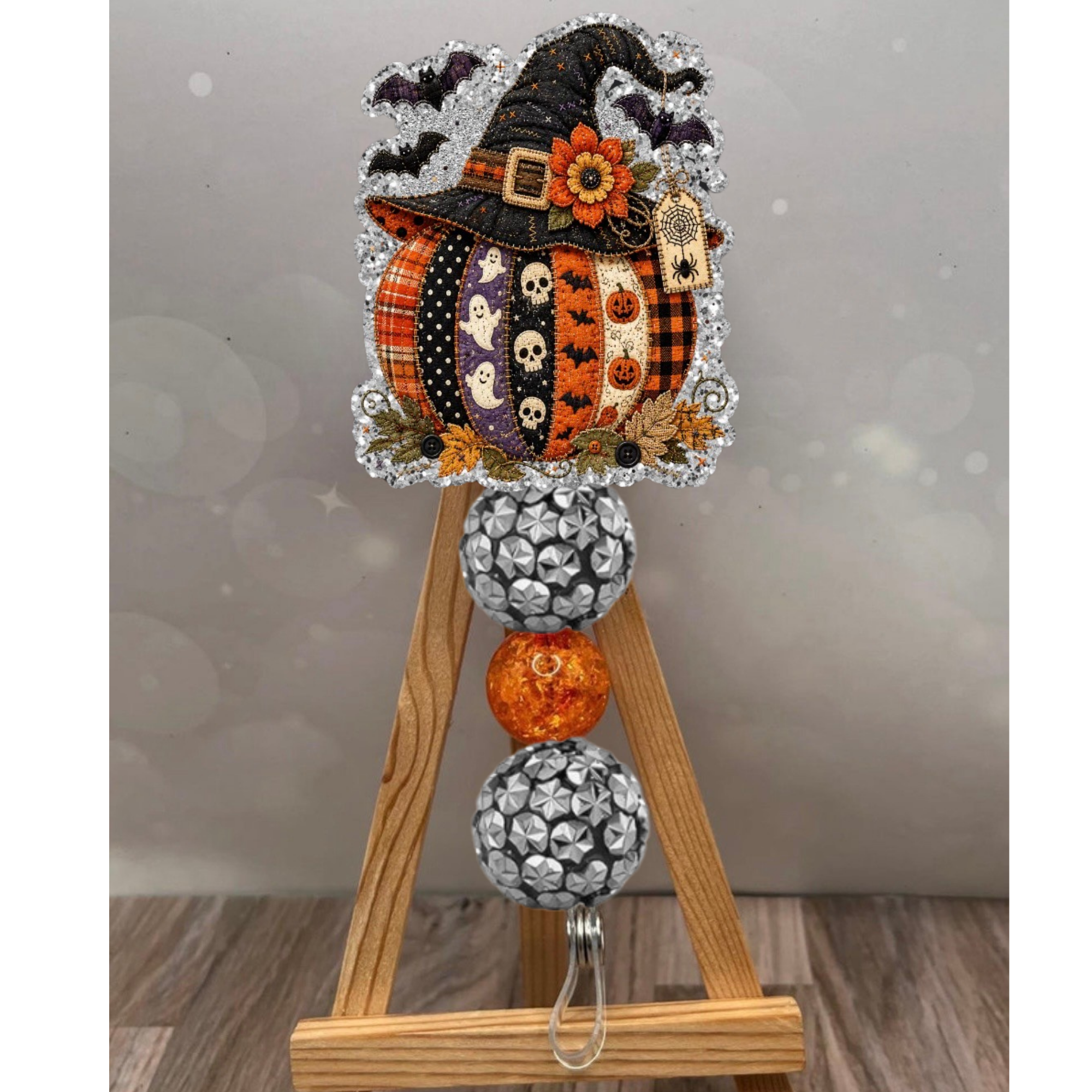 Patchwork pumpkin badge reel with glitter background, handcrafted fall design, perfect for autumn lovers.