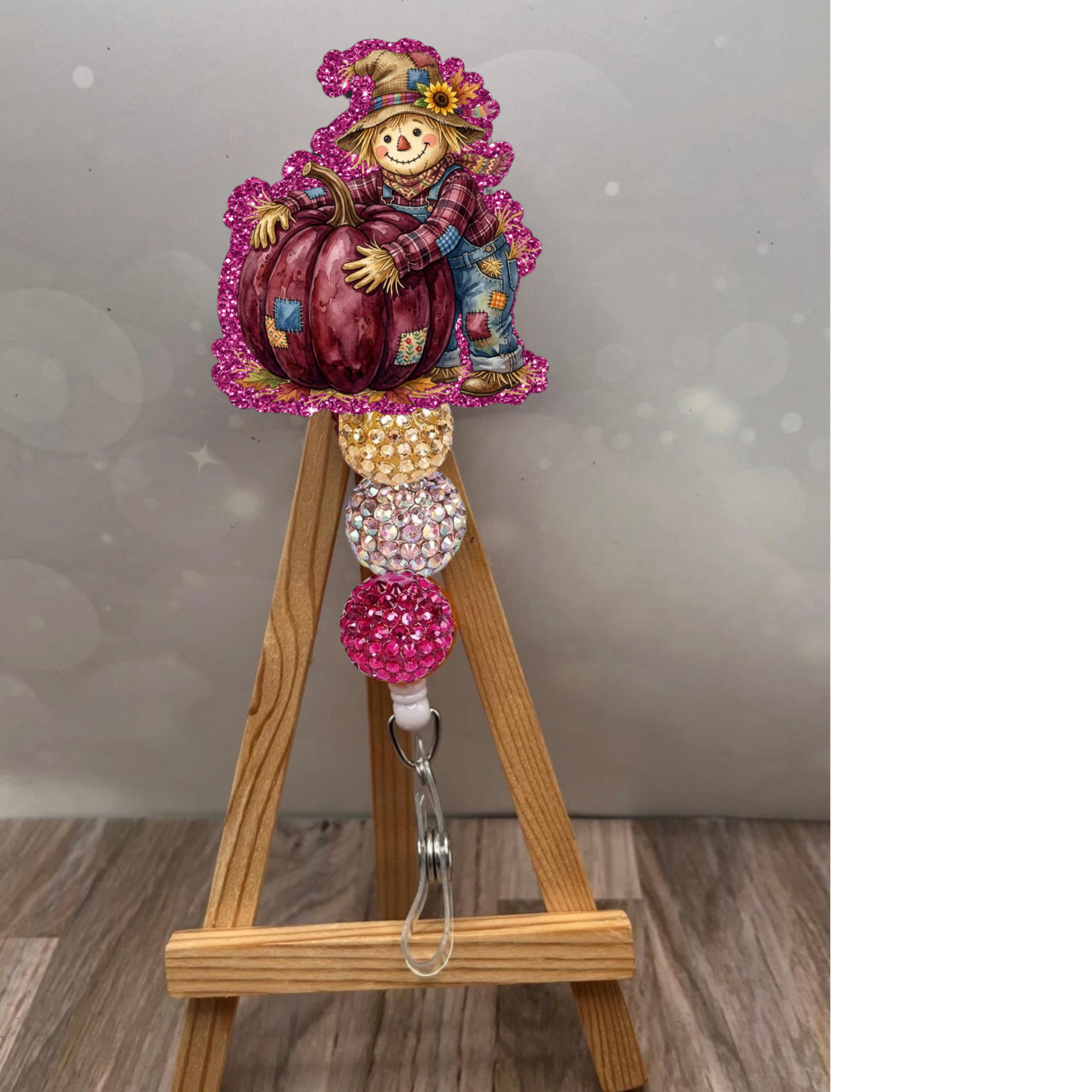 Boy scarecrow badge reel with pumpkin featuring pink glitter background and colorful decorative beads.