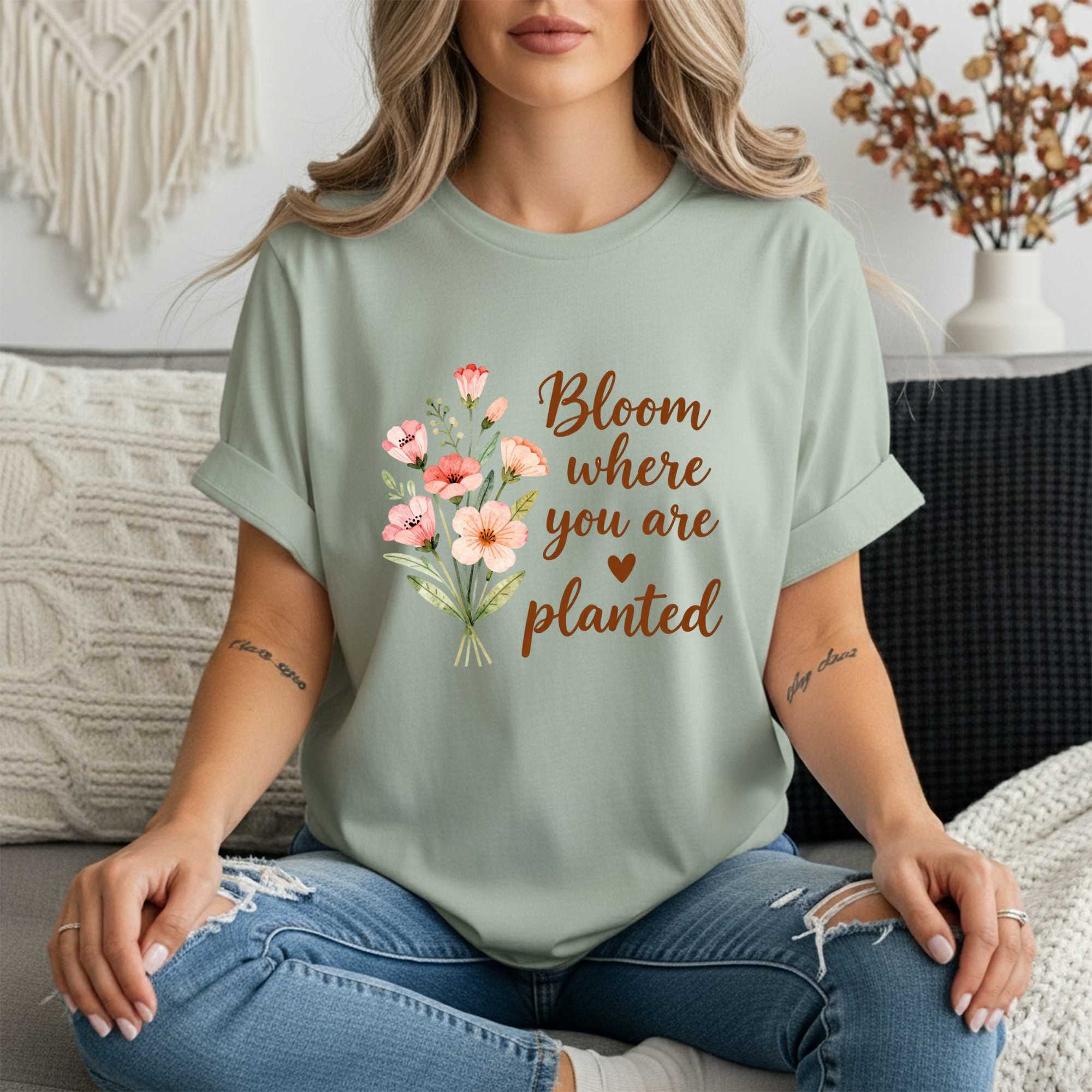 Inspirational graphic tee featuring floral design with the phrase 'Bloom where you are planted', modeled by a woman.