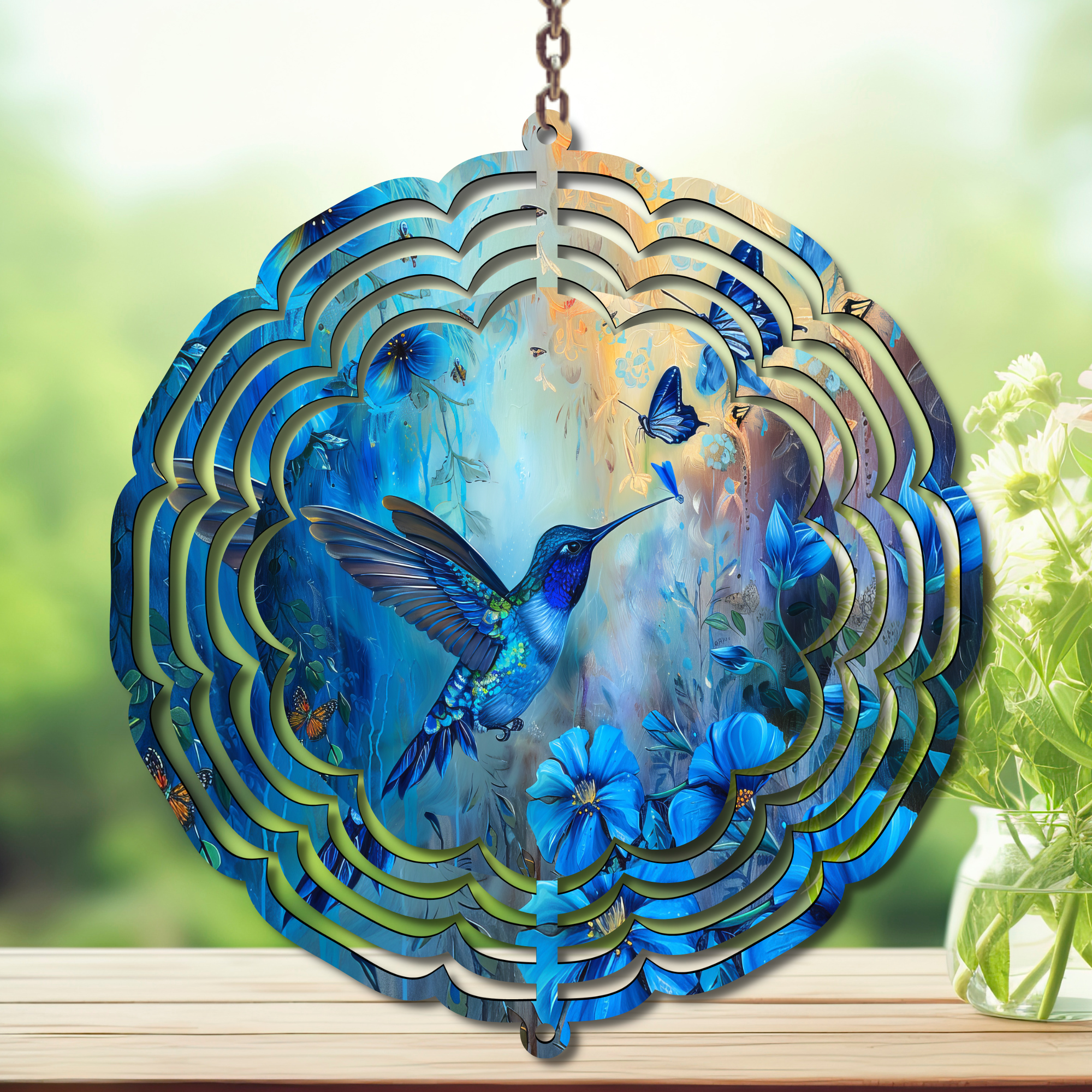 Colorful hummingbird wind spinner yard art featuring vibrant blue hues and floral designs, perfect for garden decor.