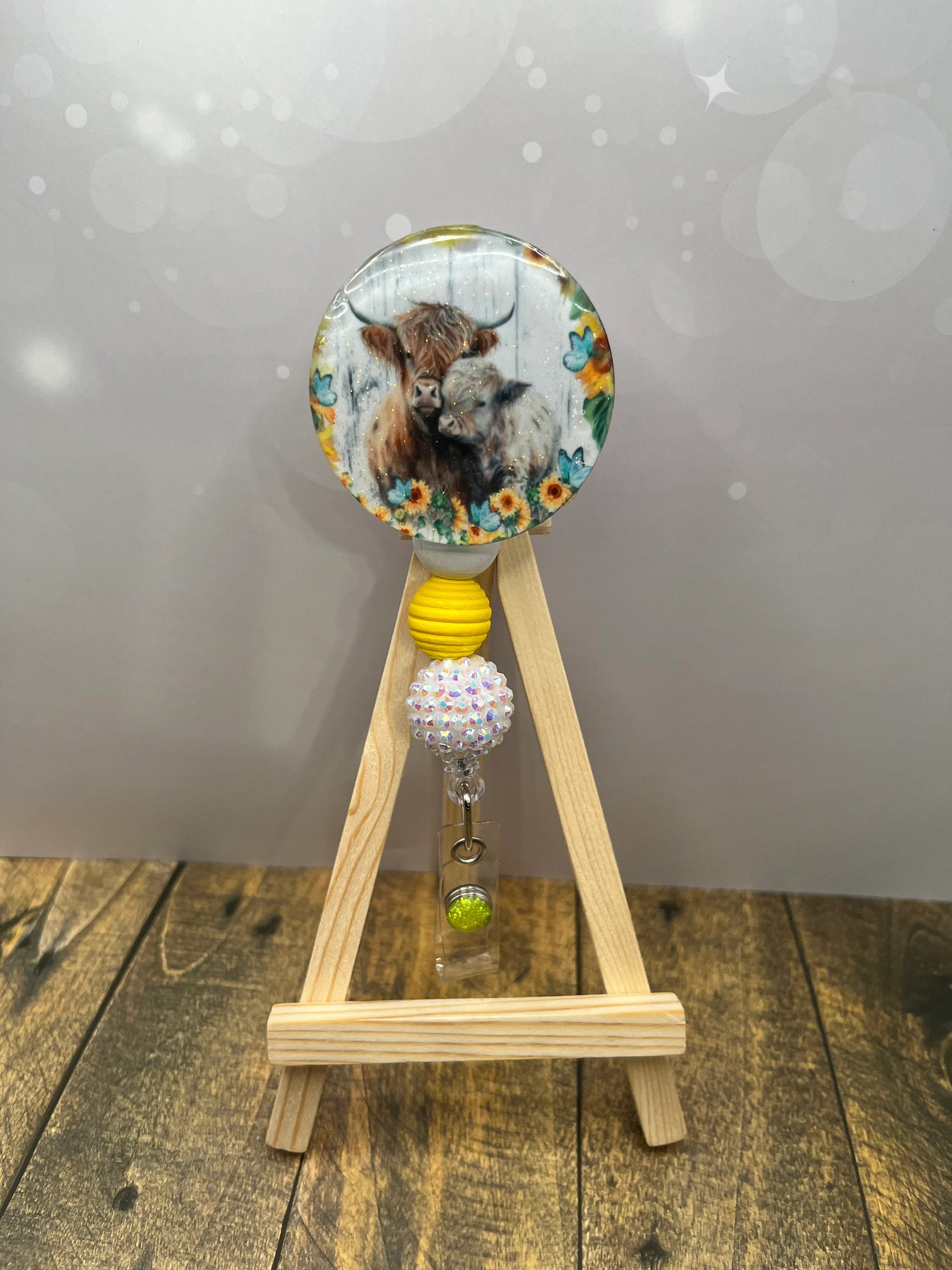 Highland cow badge pull featuring a fluffy cow design with colorful beads, perfect for brightening your workday.