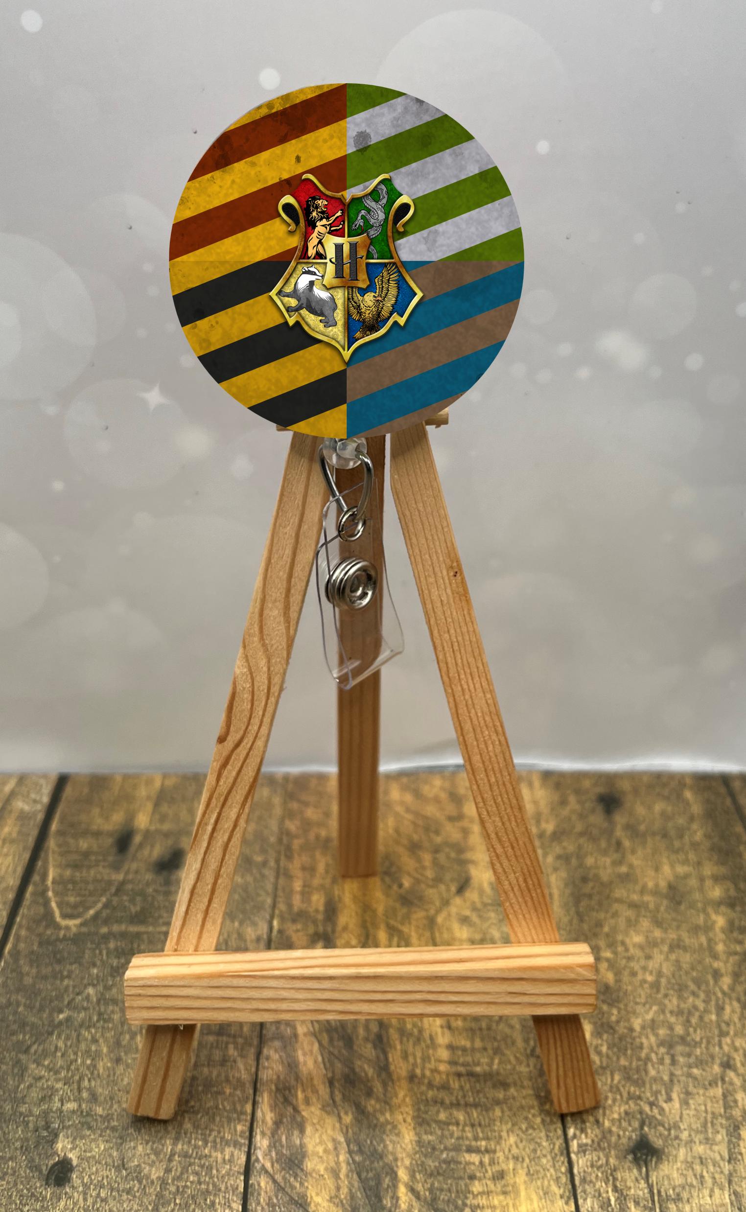 Colorful wizard badge pulls design with whimsical artwork displayed on a wooden easel.