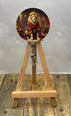 Gryffindor badge pull with glitter featuring a lion sitting majestically on a decorative stand.
