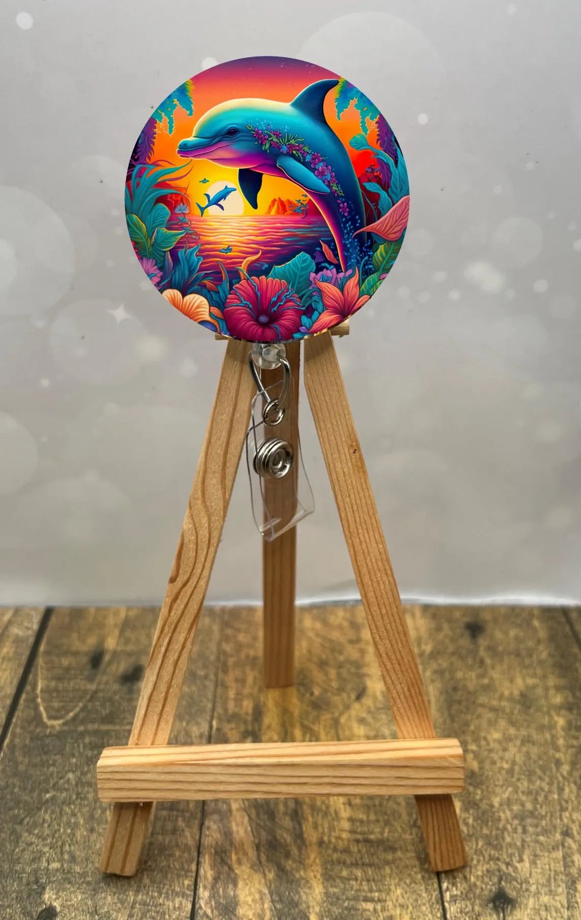 Colorful dolphin badge pull with glitter, featuring tropical flowers and ocean sunset, ideal for cheerful ID display.