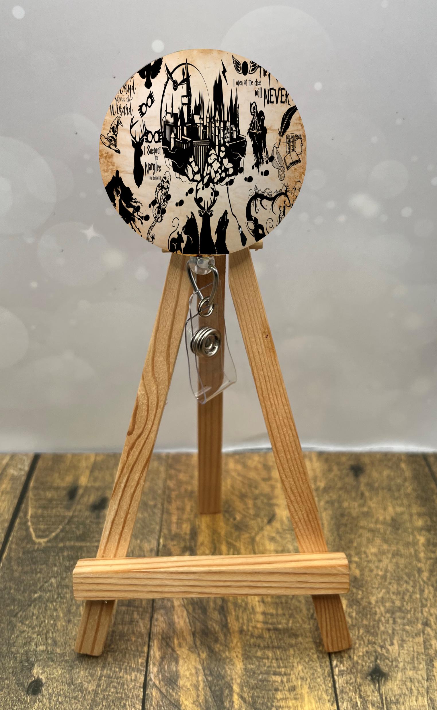 wizard badge pulls featuring whimsical wizard-themed artwork on a display easel.