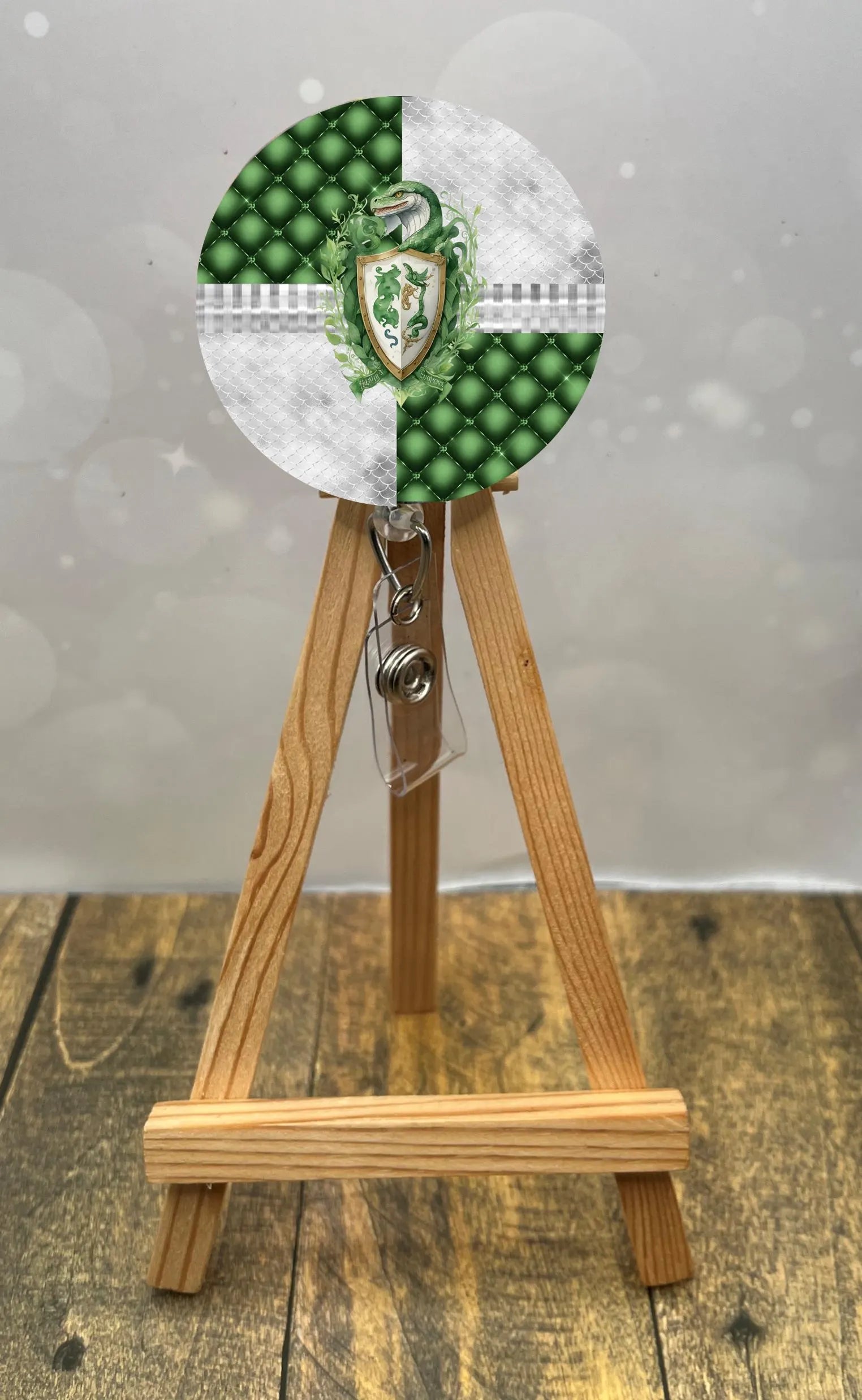 Slytherin badge pull with glitter featuring a green and silver design on a retractable badge holder.