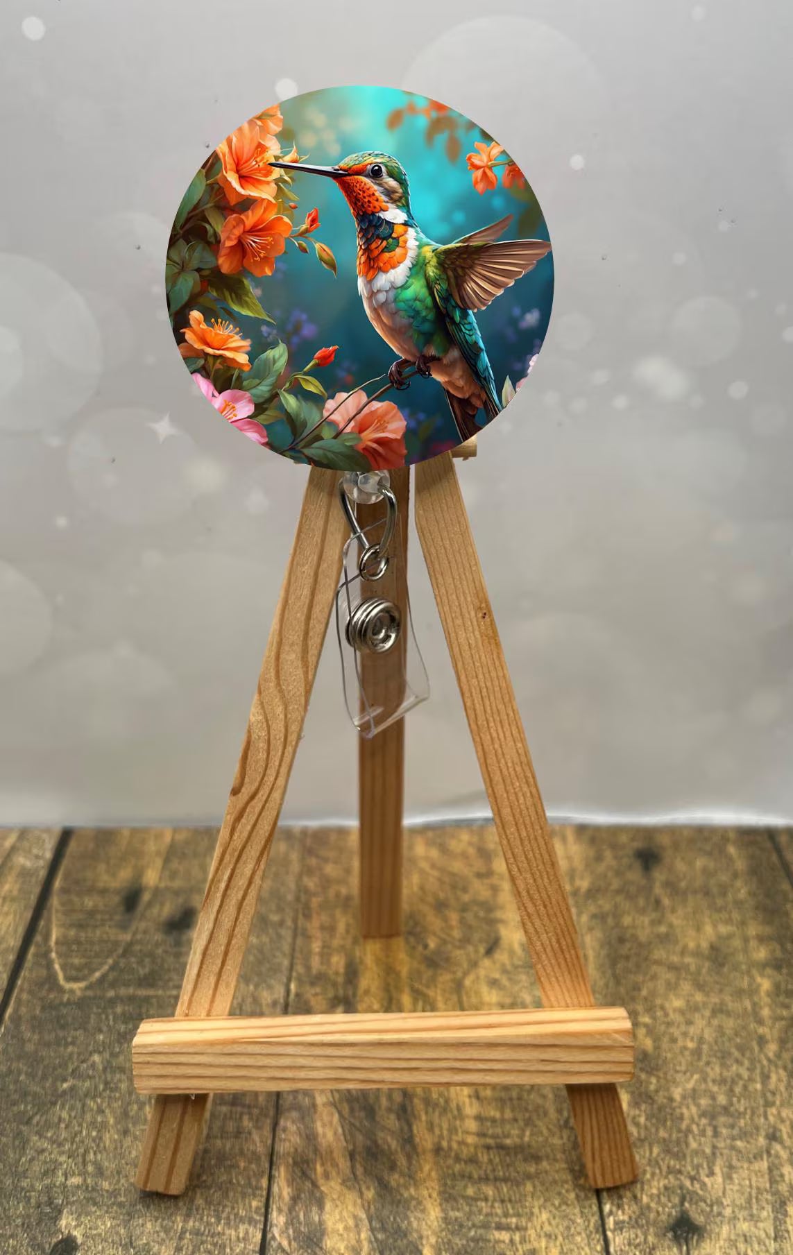 Hummingbird badge pulls featuring vibrant hummingbird with floral details on a wooden easel.