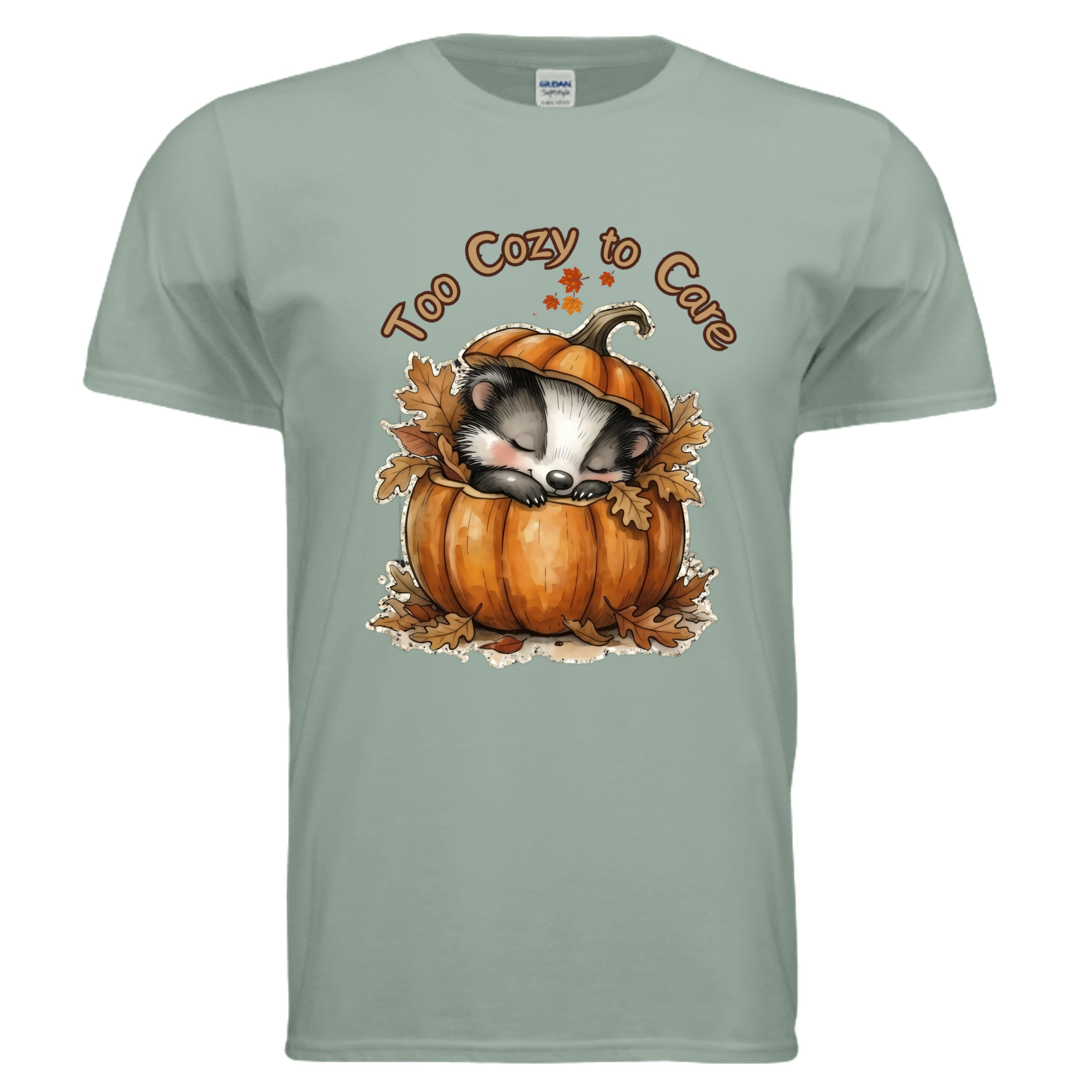 Illustration of a cozy graphic tee for fall with a sleepy badger in a pumpkin on sage color fabric.