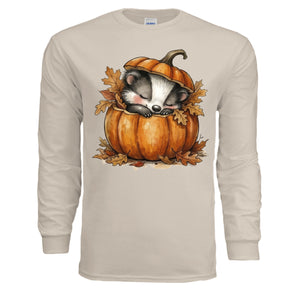 Cozy Badger Long Sleeve Tee in sand color featuring a cute badger sleeping in a pumpkin surrounded by autumn leaves.