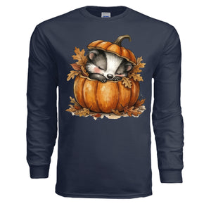 Cozy Badger Long Sleeve Tee featuring a badger in a pumpkin surrounded by autumn leaves on a navy background.