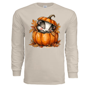 Cozy Badger long sleeve tee featuring a badger sleeping in a pumpkin with autumn leaves, in sand color.